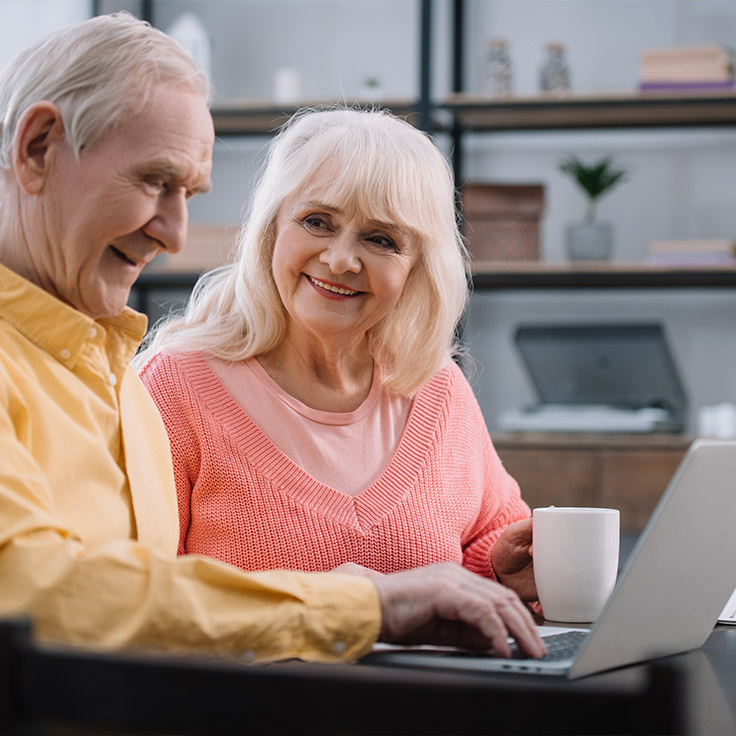 senior couple on laptop researching simple retirement income strategies