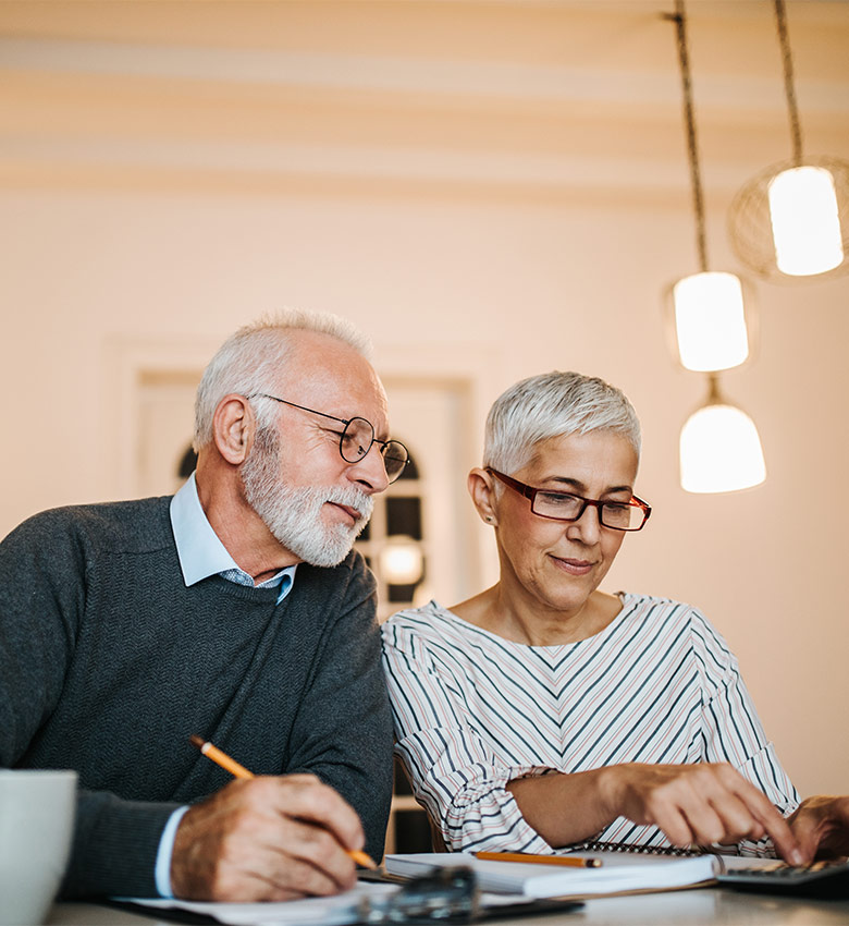 senior couple sitting at desk preparing a safe plan for retirement