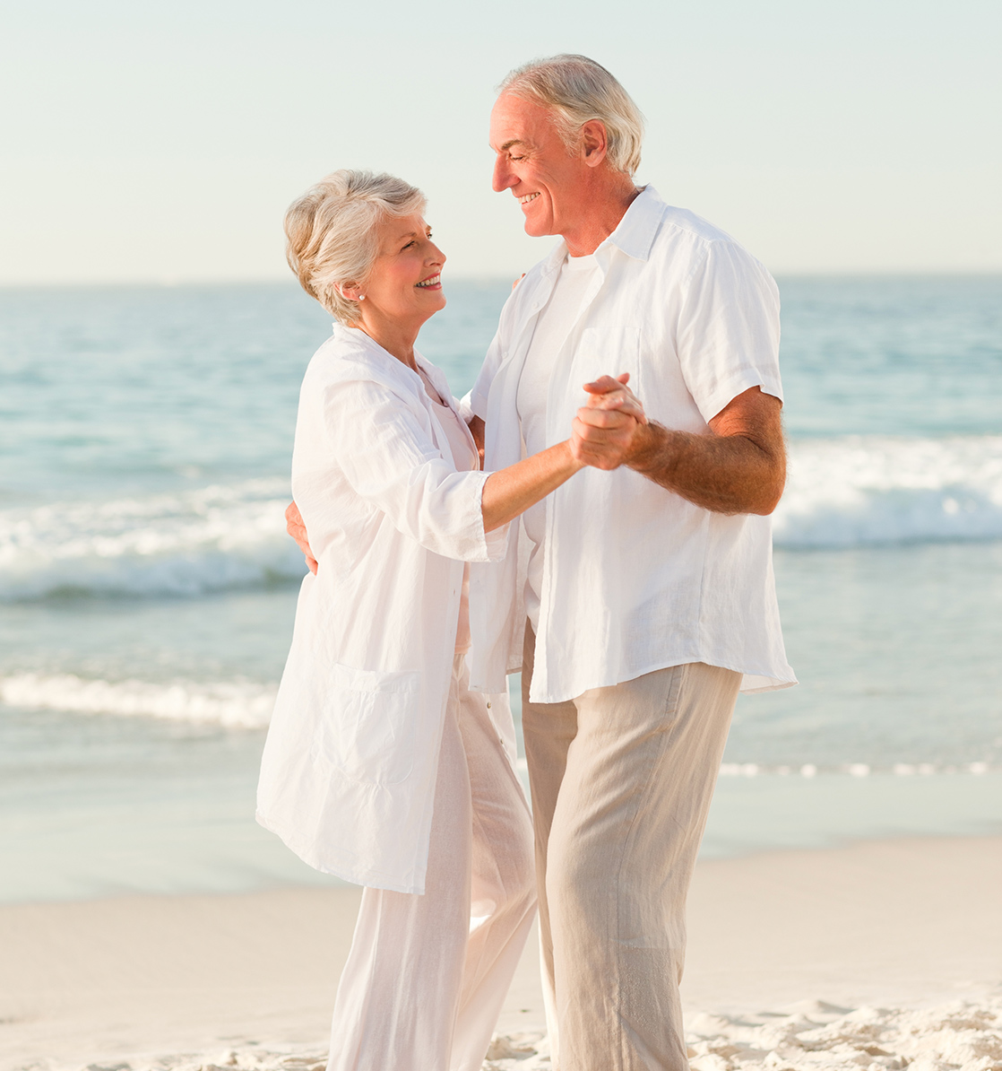 senior couple smiling and dancing on beach fixed index annuity rates lifelong financial solutions