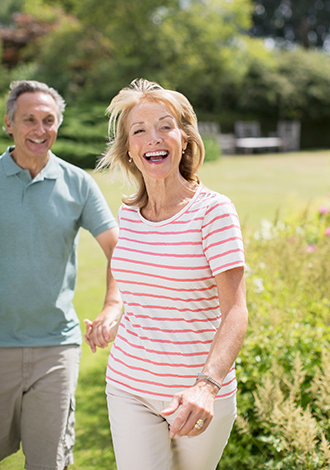 smiling senior couple holding hands outdoors annuity benefits lifelong financial solutions