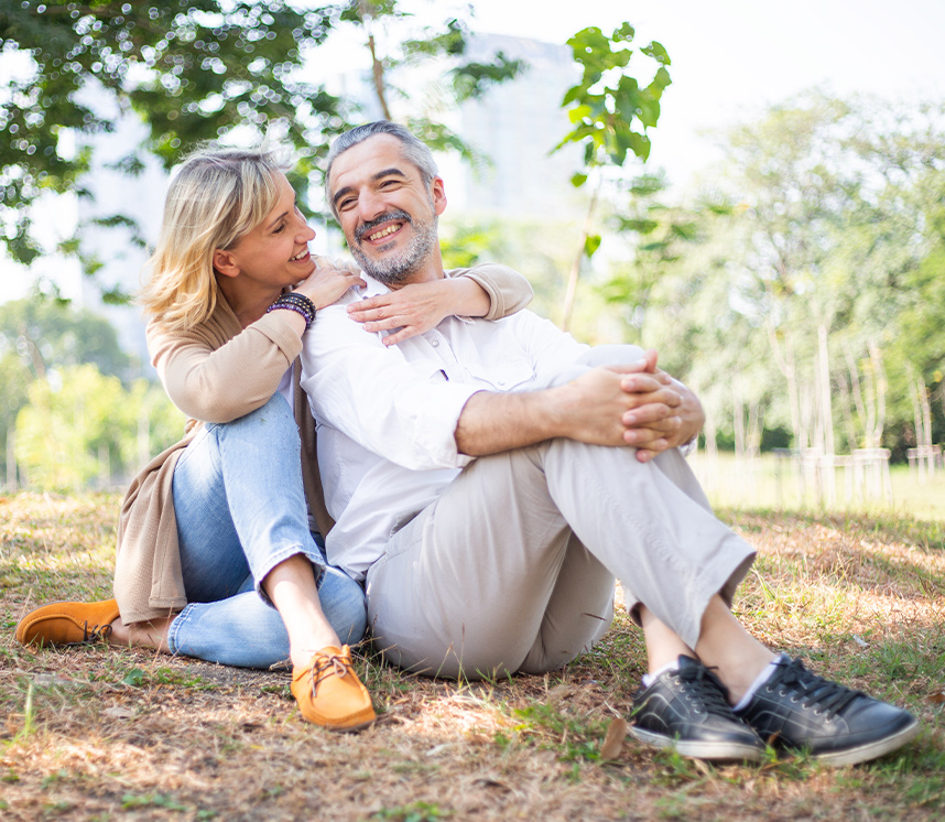 happy smiling senior couple sitting on grass retirement life insurance lifelong financial solutions